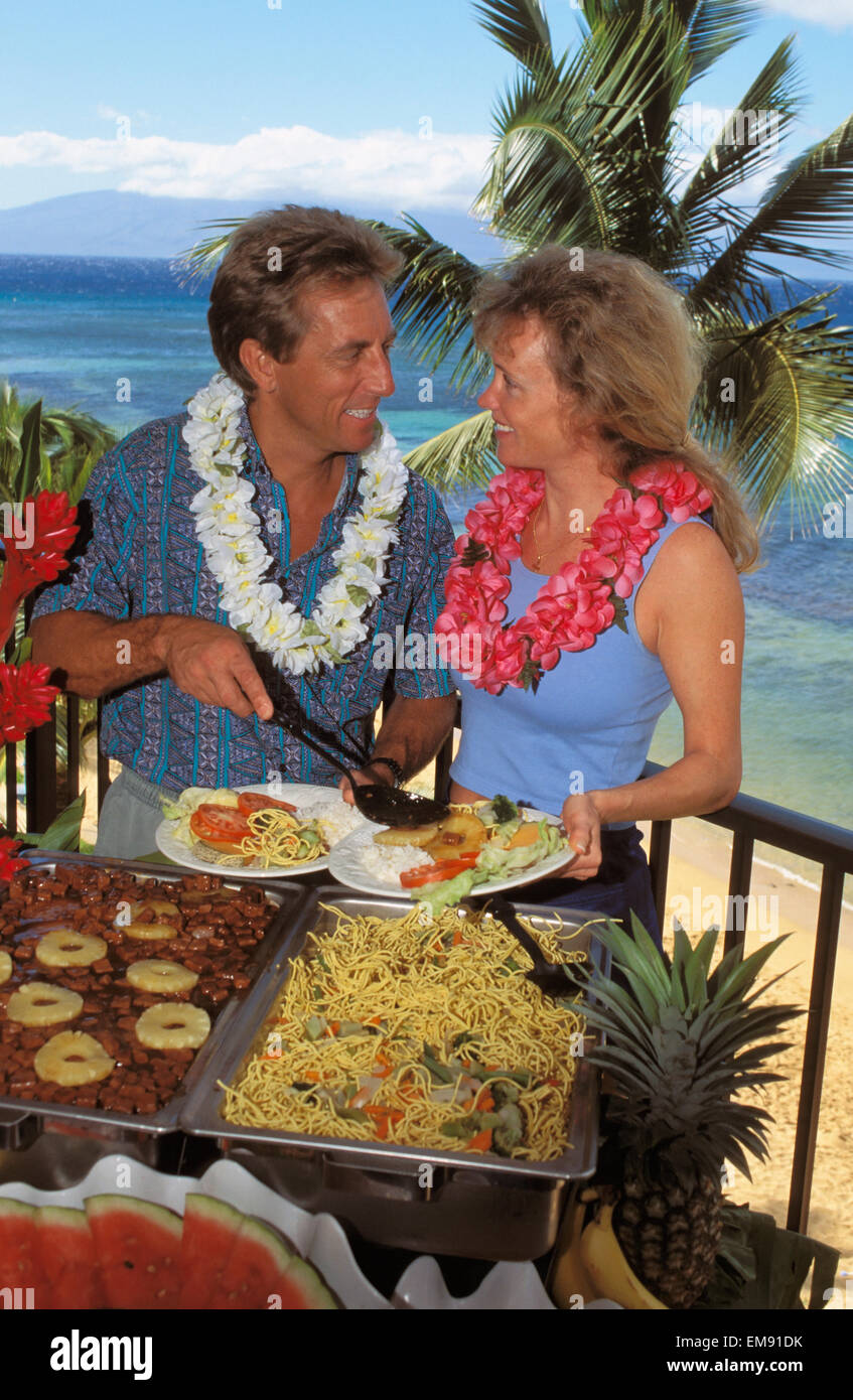 Hawaii, paar Luau Buffet, Meer und Palmen im Hintergrund. Stockfoto