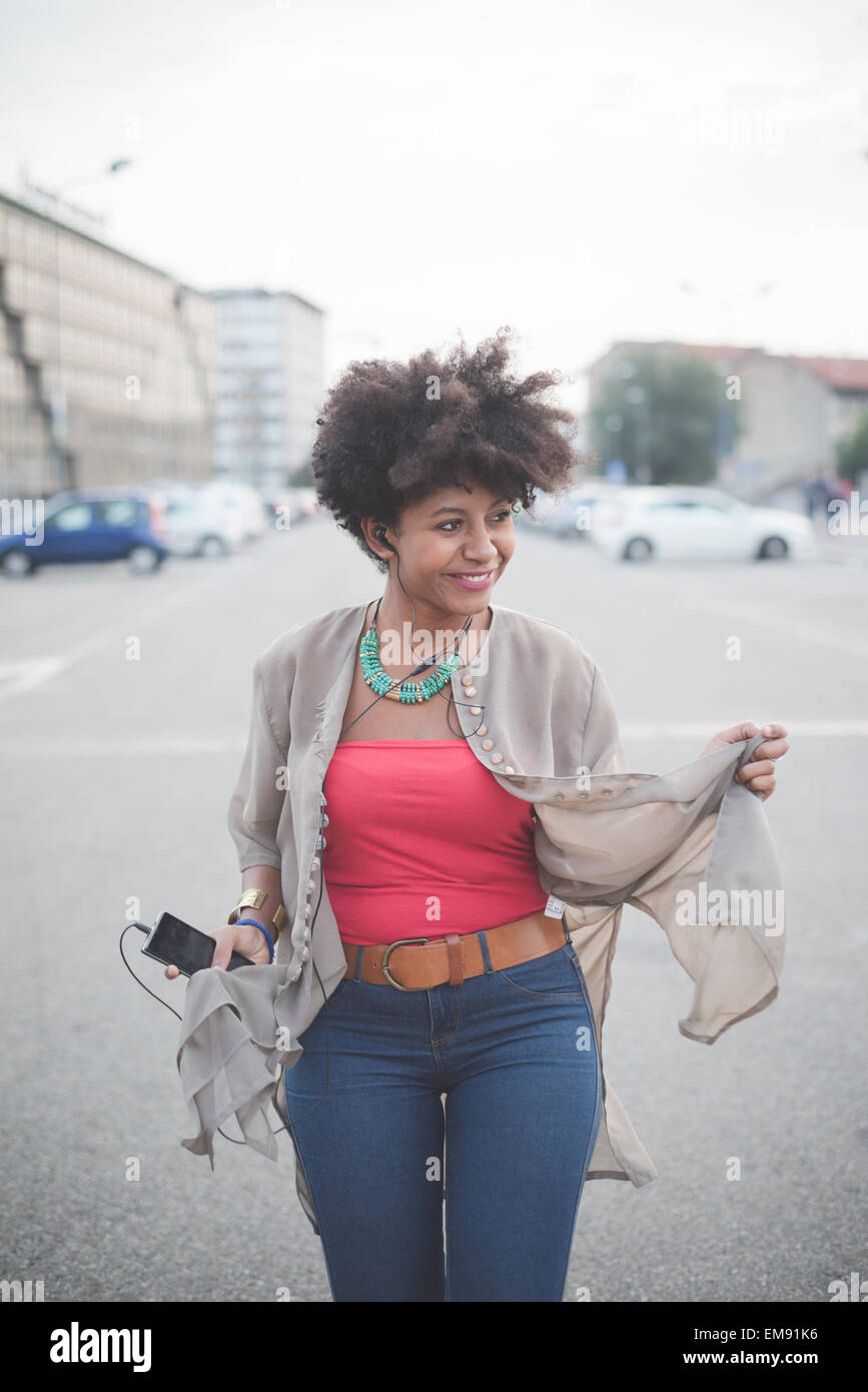 Junge Frau gehen und tanzen Kopfhörer Musik auf Parkplatz Stockfoto