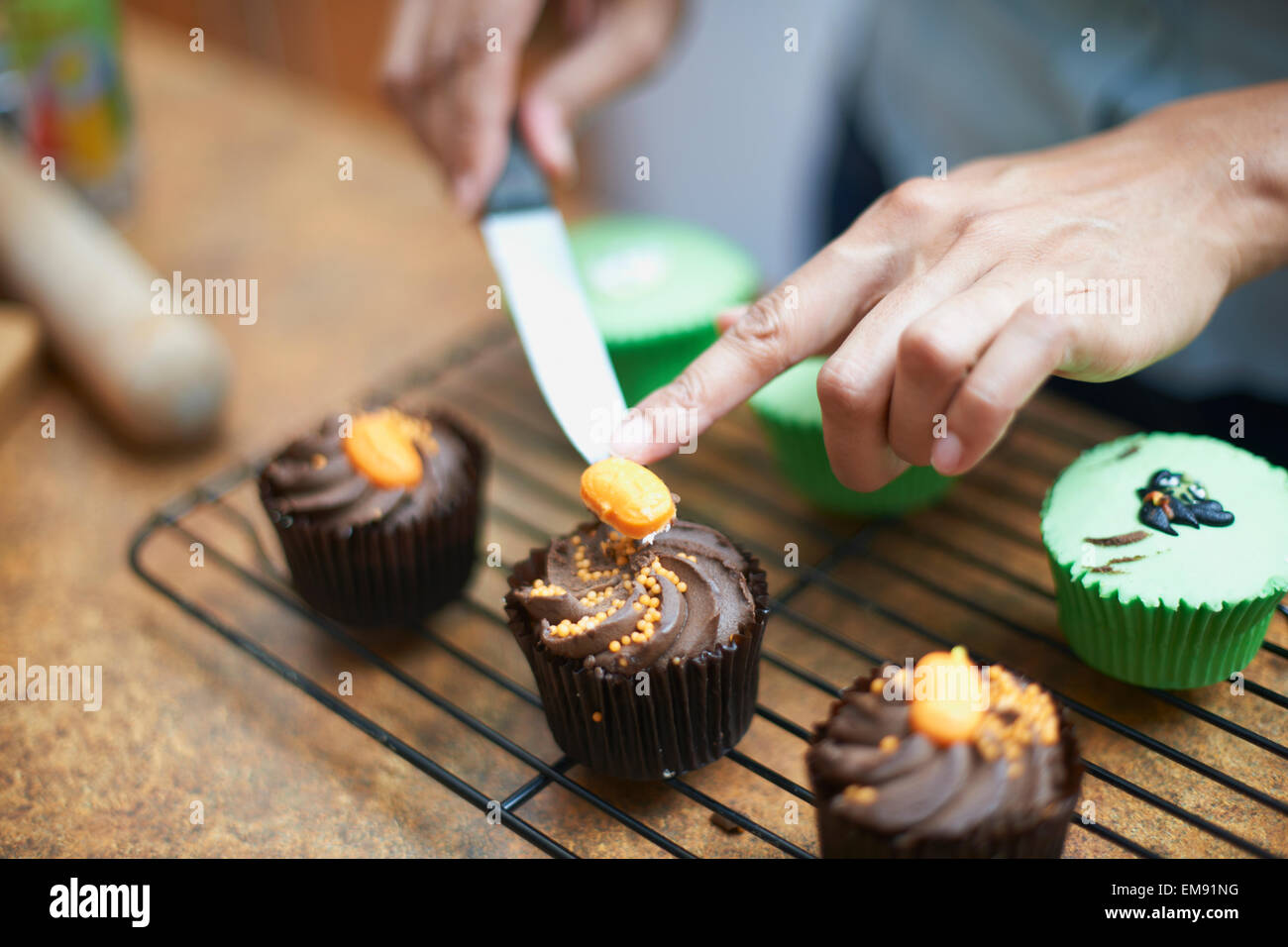 Womans Hände Vereisung Tasse Kuchen auf Rack-Kühlung Stockfoto