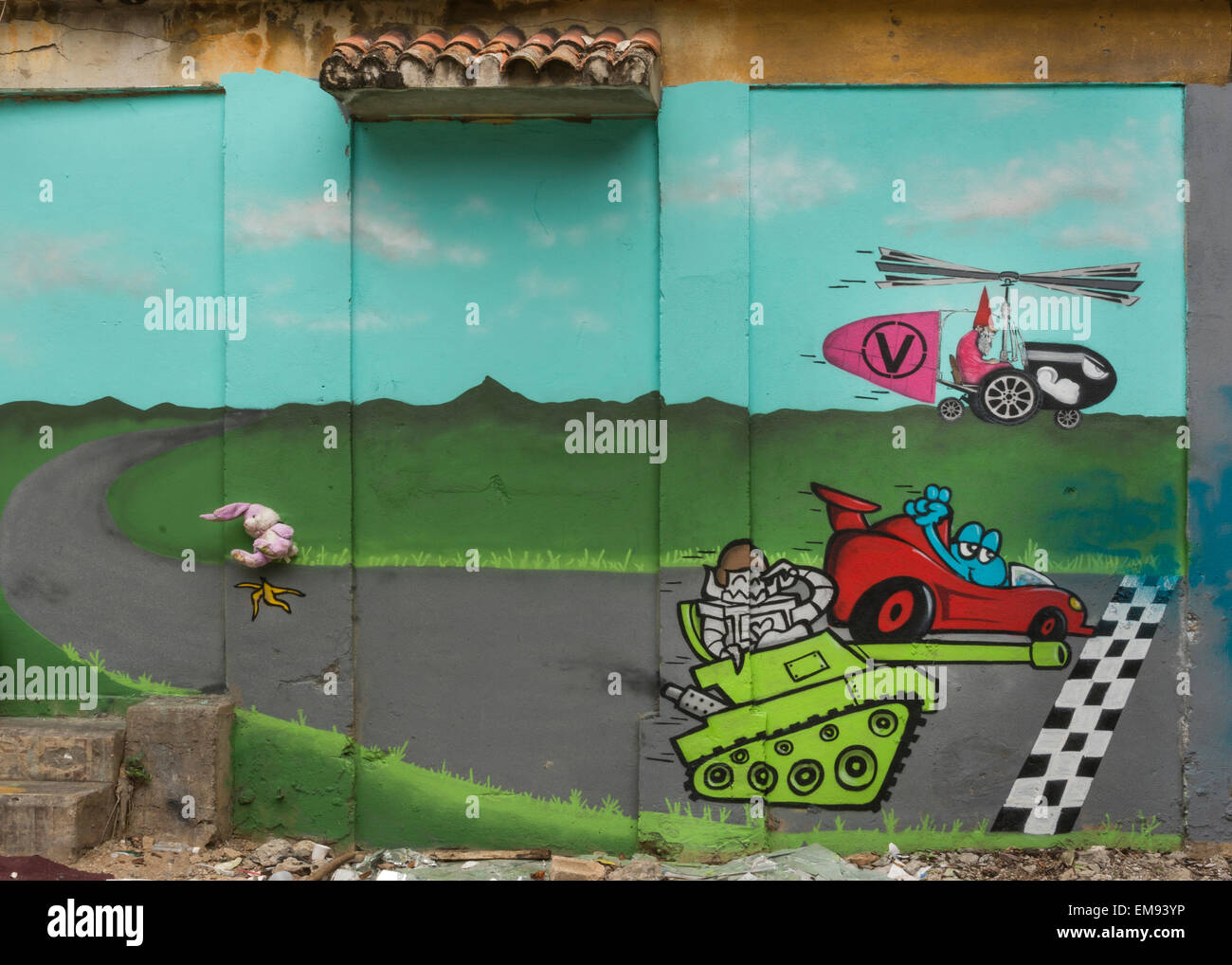 Graffiti eines Rennens zwischen Tank, Auto und Hubschrauber. Stockfoto