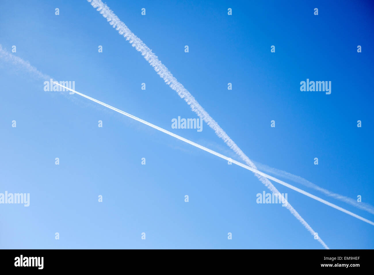 Jet-Flugzeug-Kondensstreifen Streifen in einem X-Muster über ein strahlend blauer Himmel. Stockfoto
