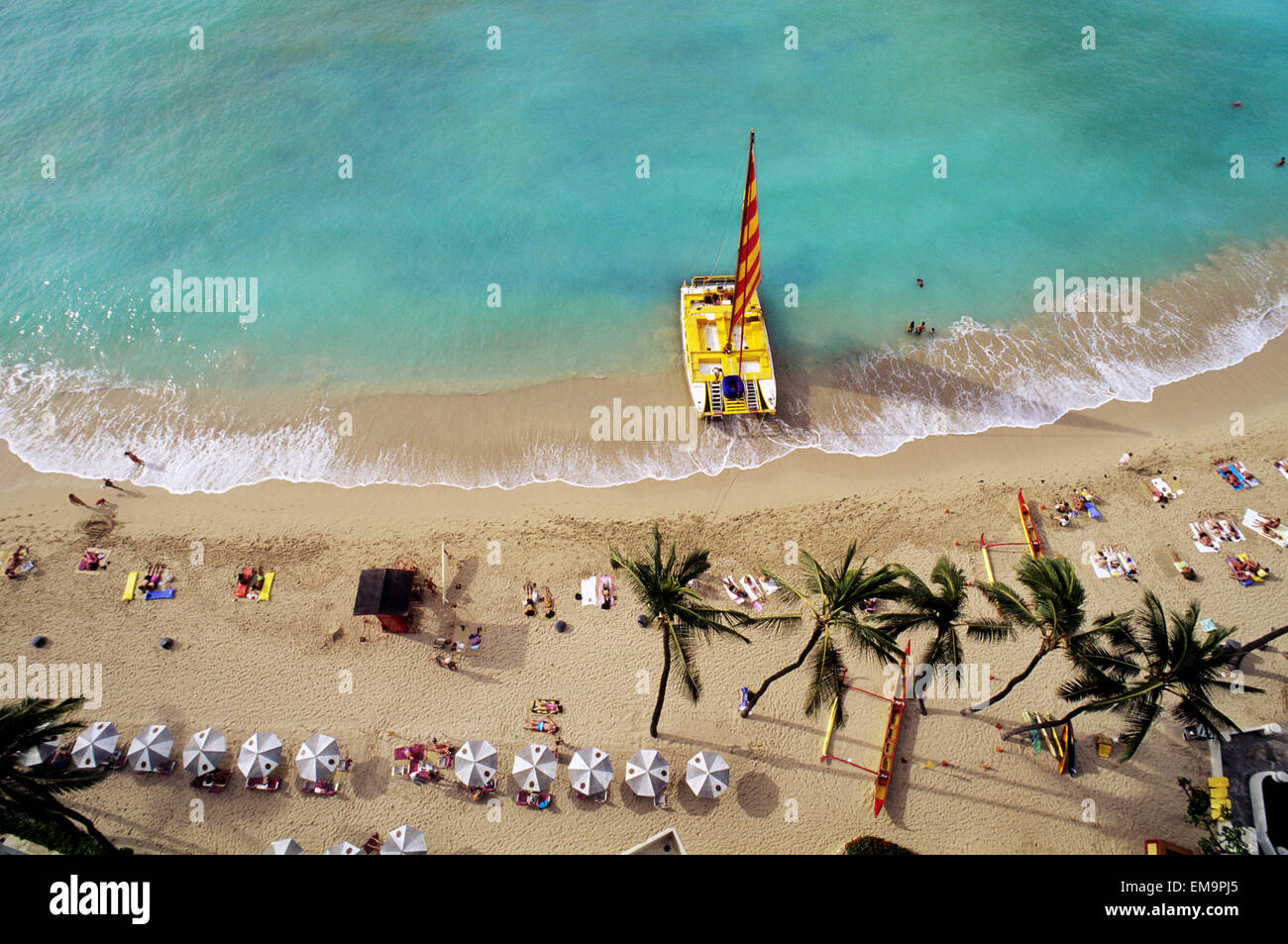 Hawaii, Oahu, Waikiki Beach mit Katamaran, Sonnenschirmen und Urlauber am Strand, Blick von oben Stockfoto