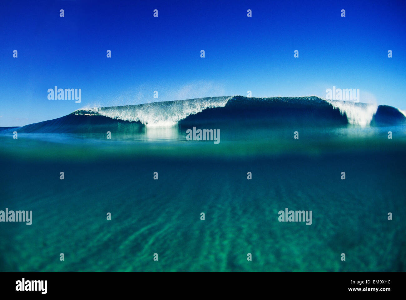 Welle brechen In Ferne, glasigen türkis Wasser im Vordergrund Stockfoto