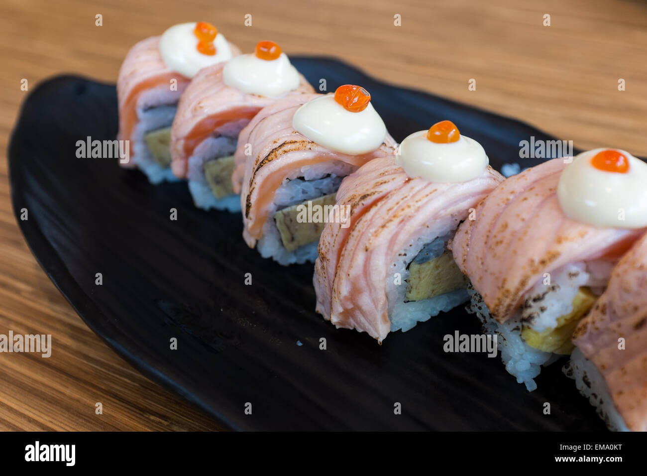 Lachs Sushi-Rollen mit Lachsrogen an der Spitze Stockfoto