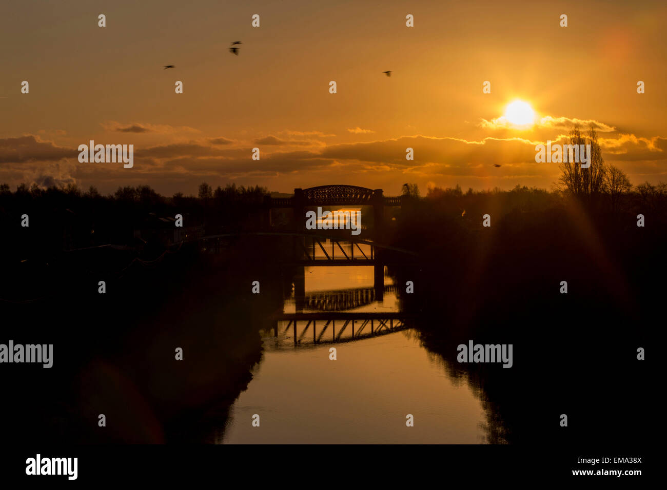 Die Sonne geht über als Manchester Ship Canal. Bild von Stockton Heide-Brücke in Richtung Manchester im Rückblick. Stockfoto