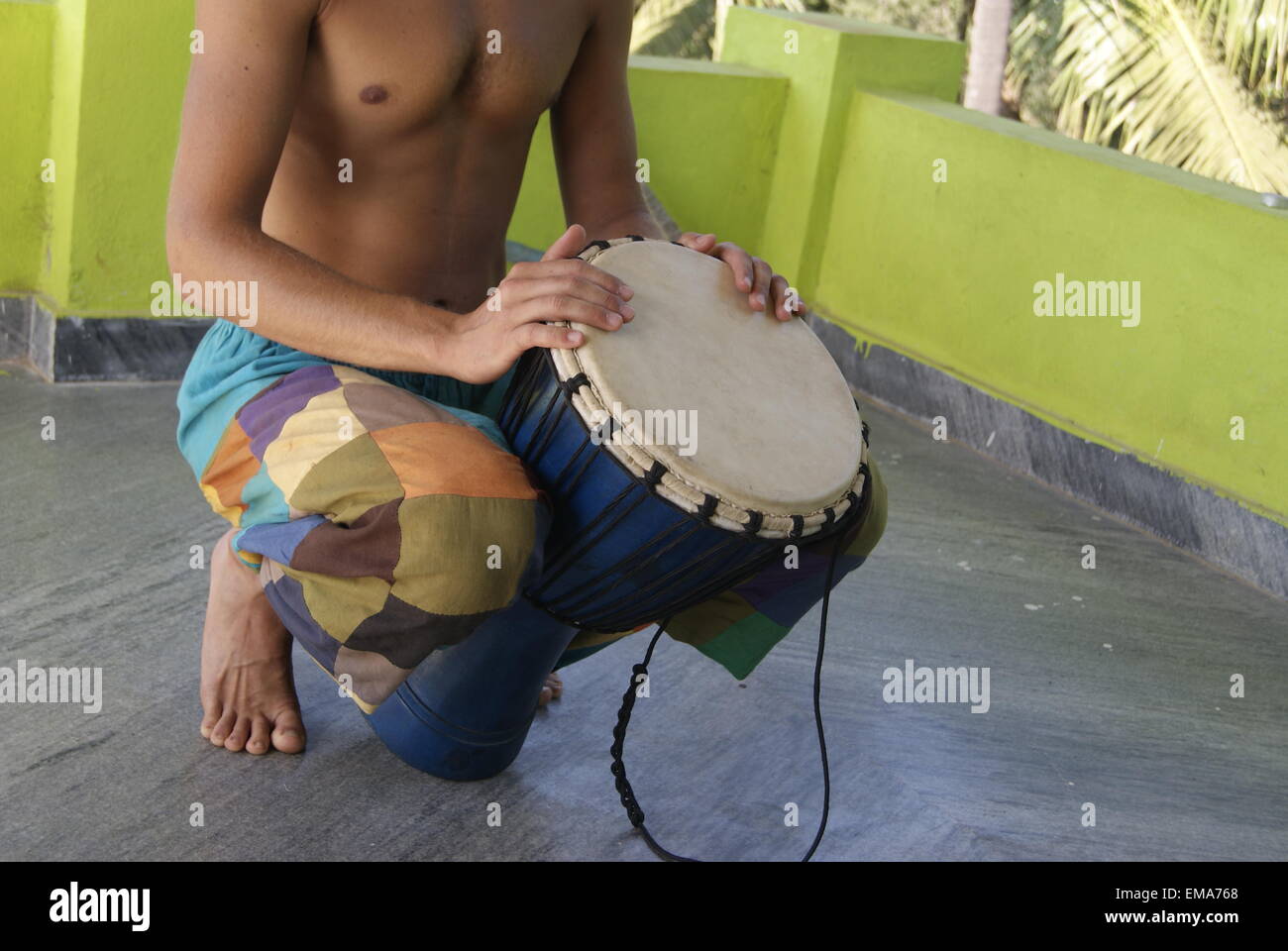 Junge europäische Kerl gegerbt spielt indische Trommel Stockfoto