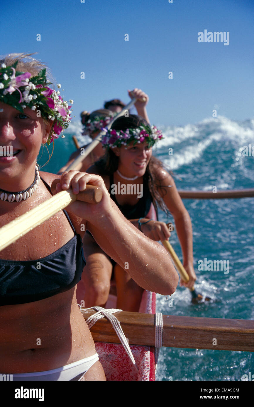 Close-up Mädchen tragen Haku Lei paddeln Auslegerkanus, Welle dahinter Stockfoto