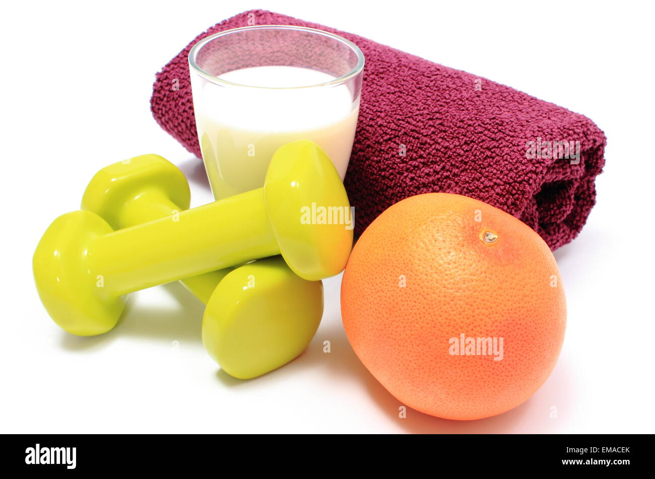 Grüne Hanteln und lila Handtuch für den Einsatz in Fitness, frische Grapefruit und Glas Milch, Konzept für gesunde Ernährung Stockfoto