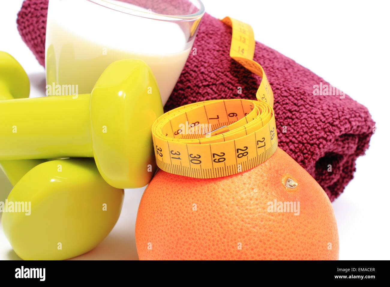 Grüne Hanteln und lila Handtuch für den Einsatz in Fitness, frische Grapefruit, Glas Milch und Maßband, Stockfoto