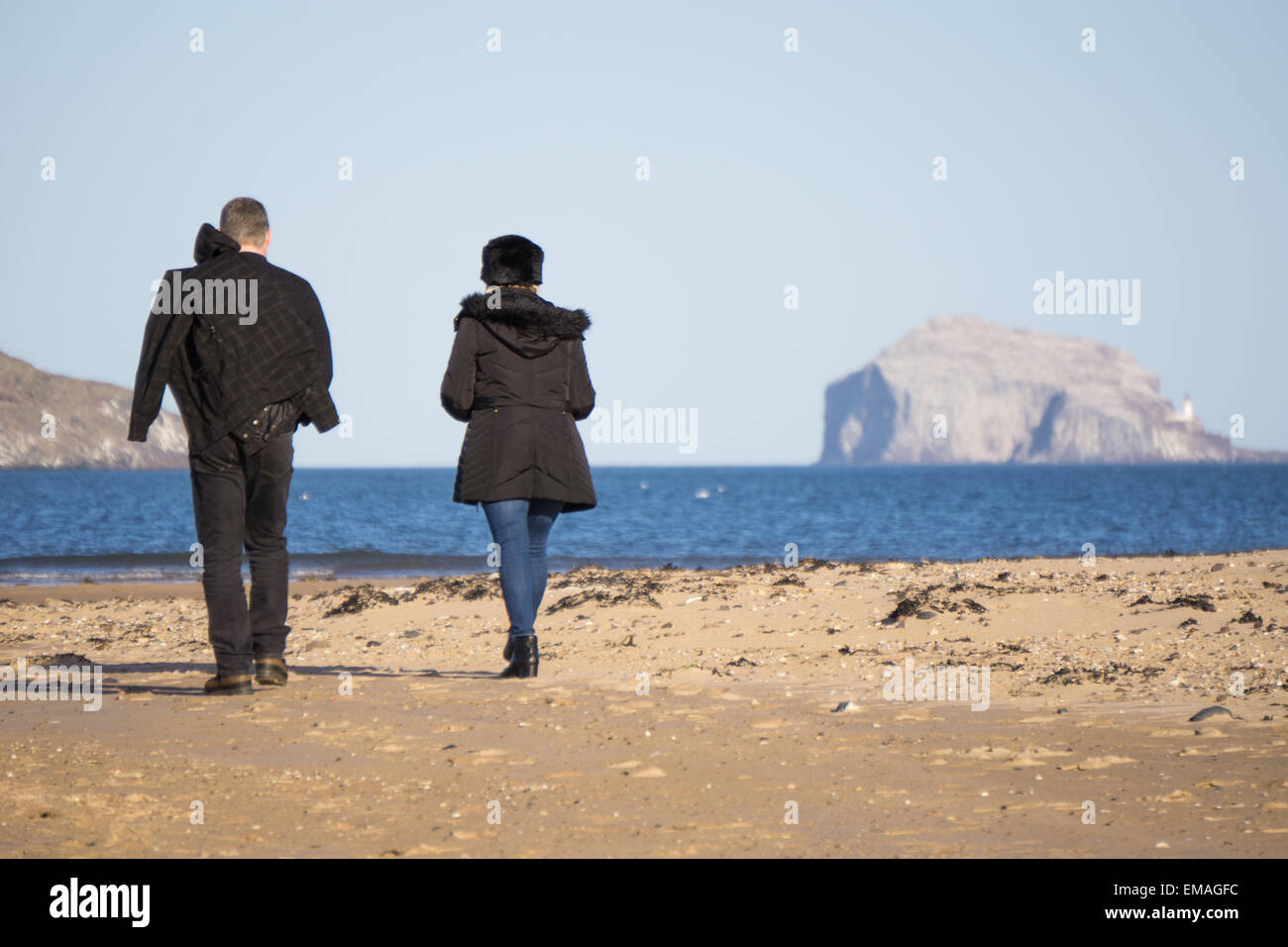 Paar Wallking am Strand von Yellowcraigs, Bass Rock in Ferne Stockfoto