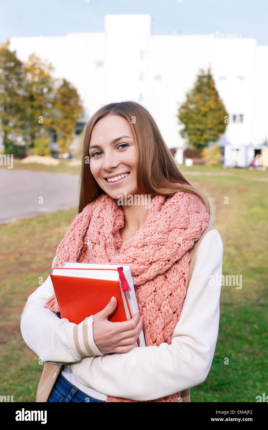 Schüler mit Büchern stehen und blickte in die Kamera auf dem campus Stockfoto