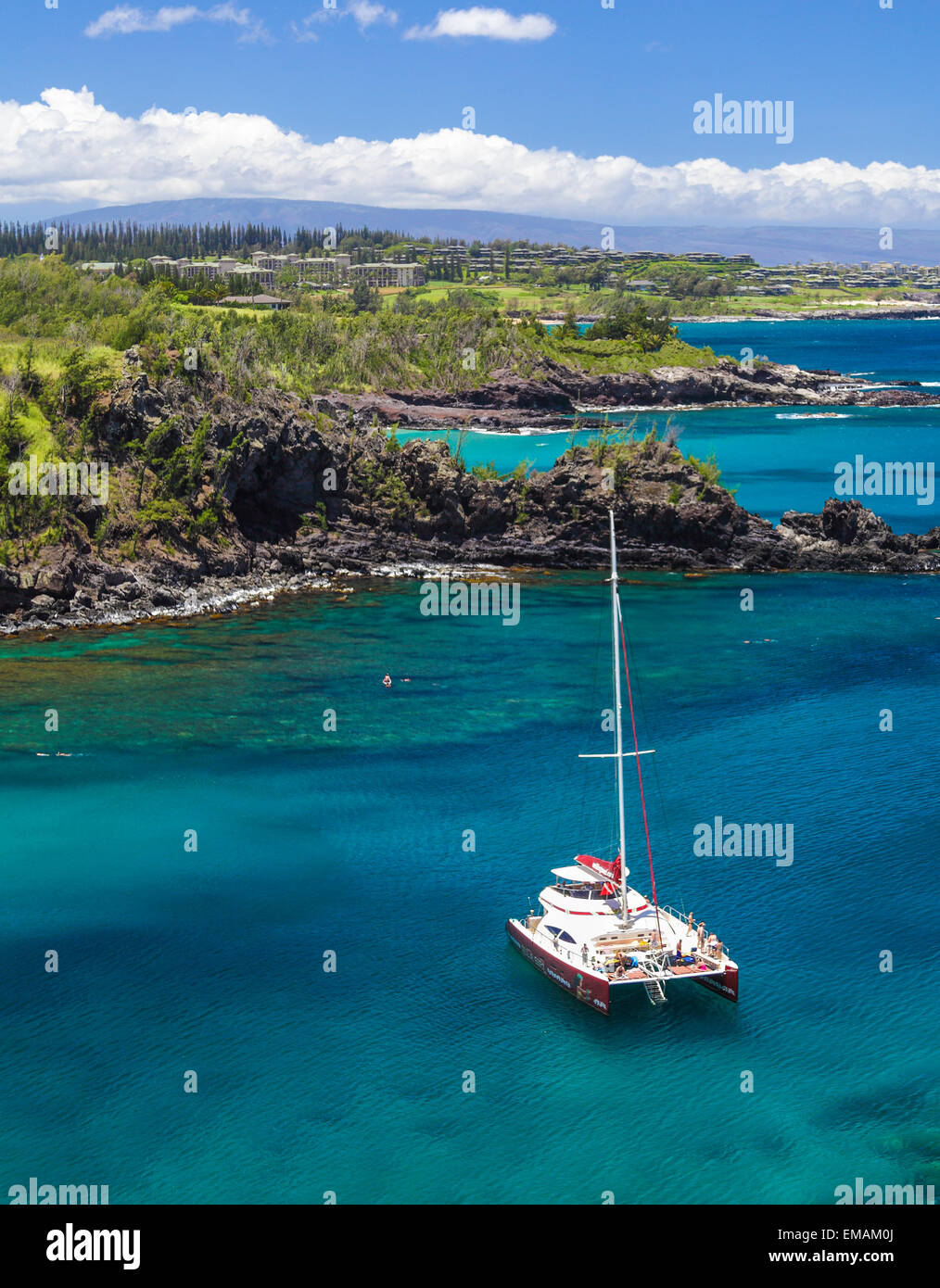 Schnorchler und Ausflugsschiff Hula Girl in Honolua Bay, mit Kapalua in Ferne Stockfoto