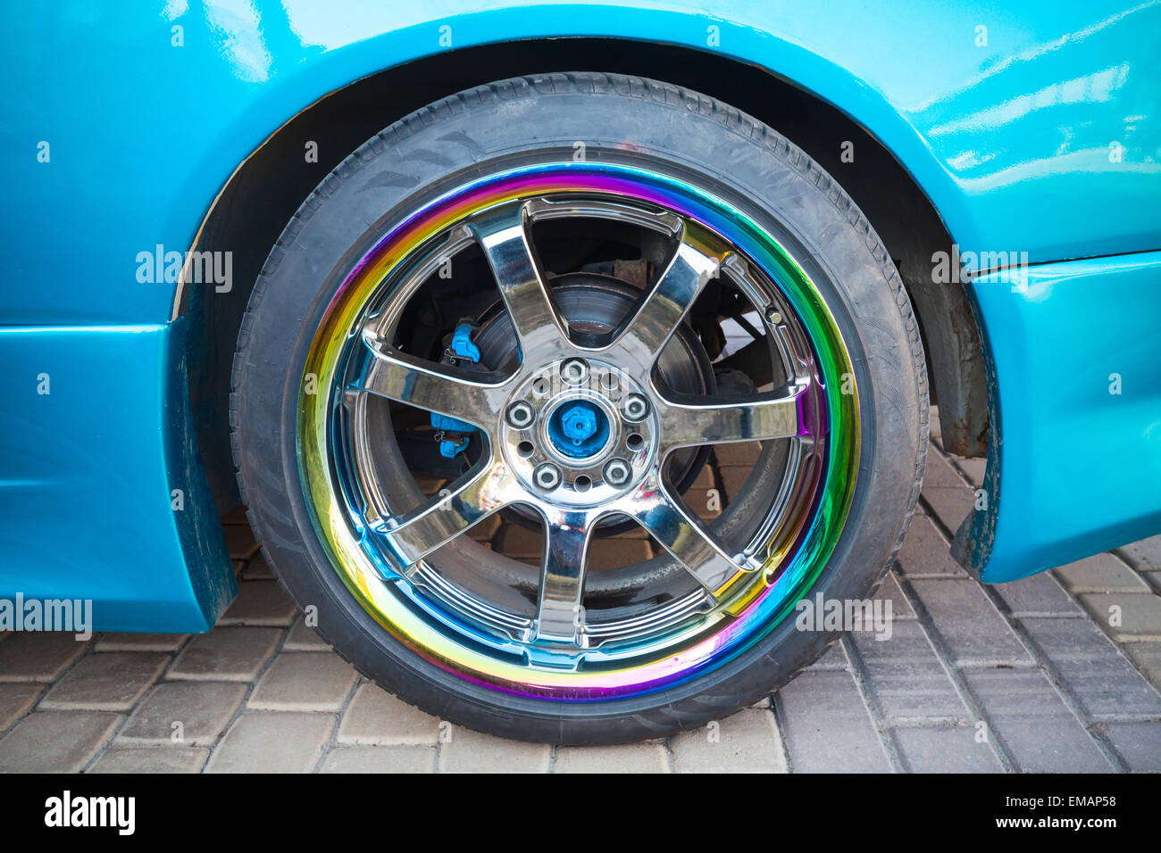 Moderne blaue Sport Auto Fragment mit Rad auf bunten metallische Scheibe, Nahaufnahme Foto Stockfoto