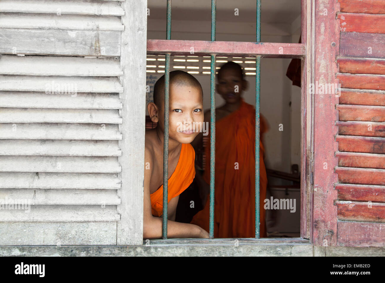 Ein junger Mönch Blick durch Fenster. Stockfoto