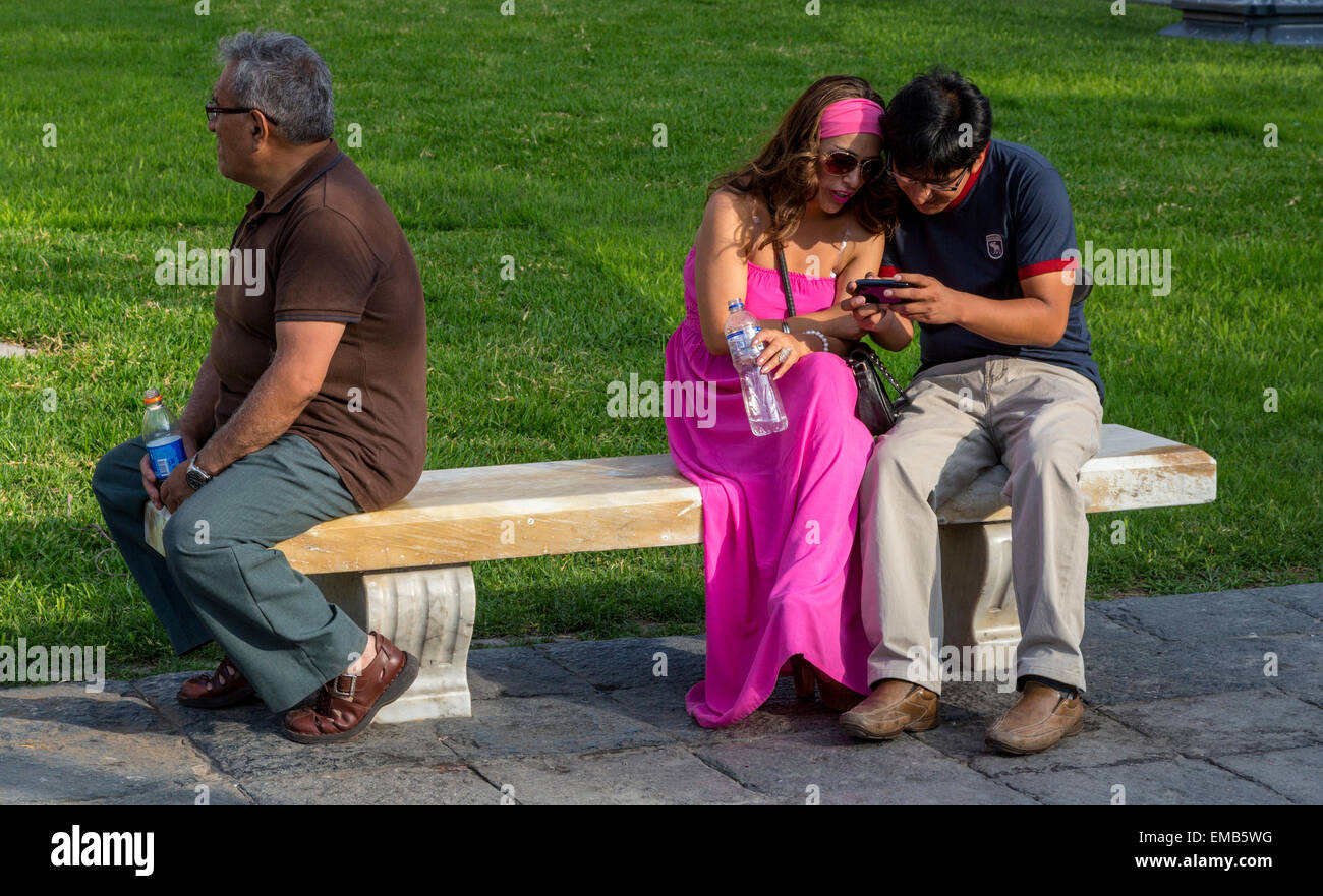 Peru, Lima.  Ein paar Überprüfung Handy, Plaza de Armas. Stockfoto