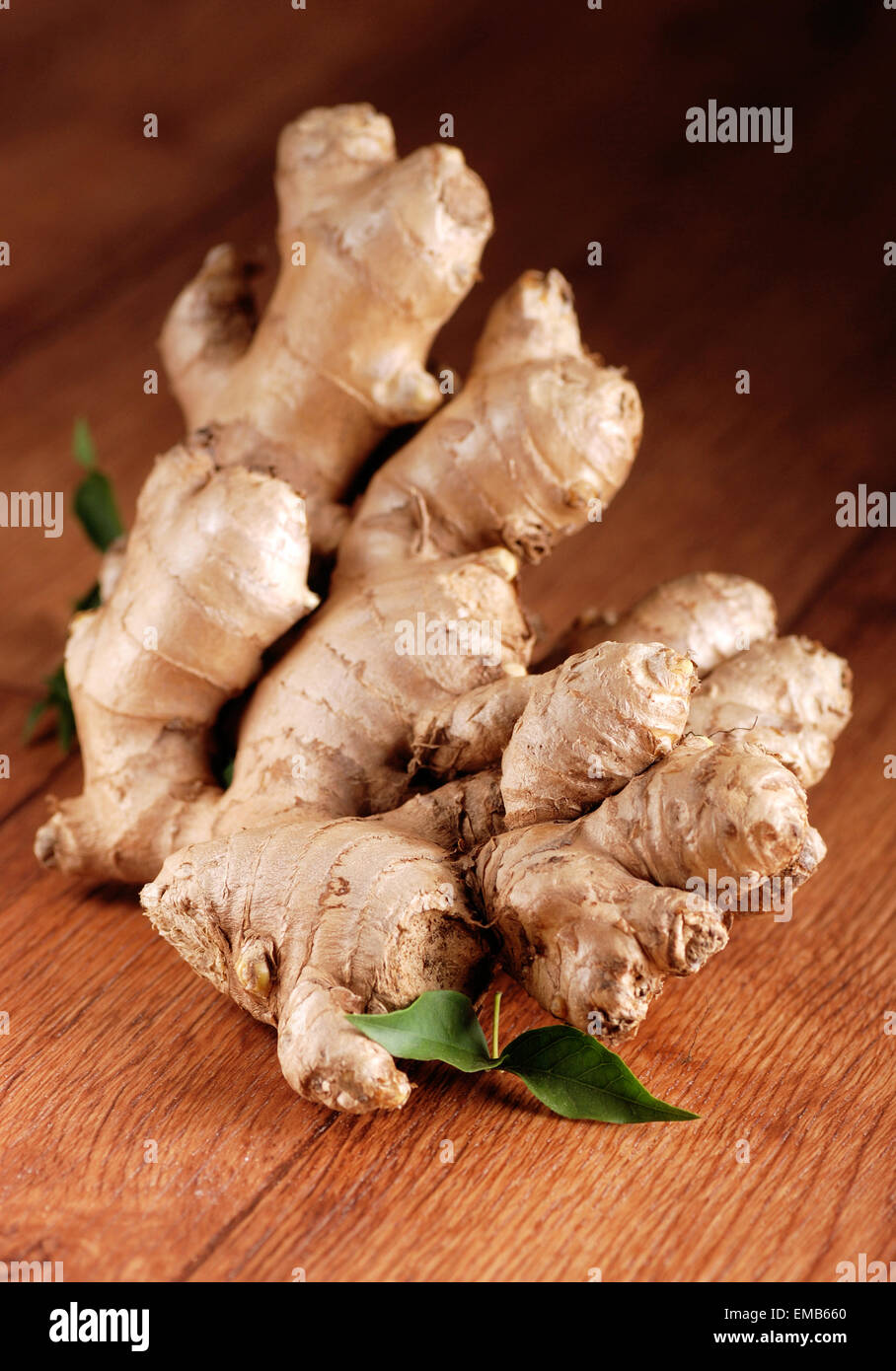 Bio Ingwer im Vordergrund auf Holztisch Stockfoto