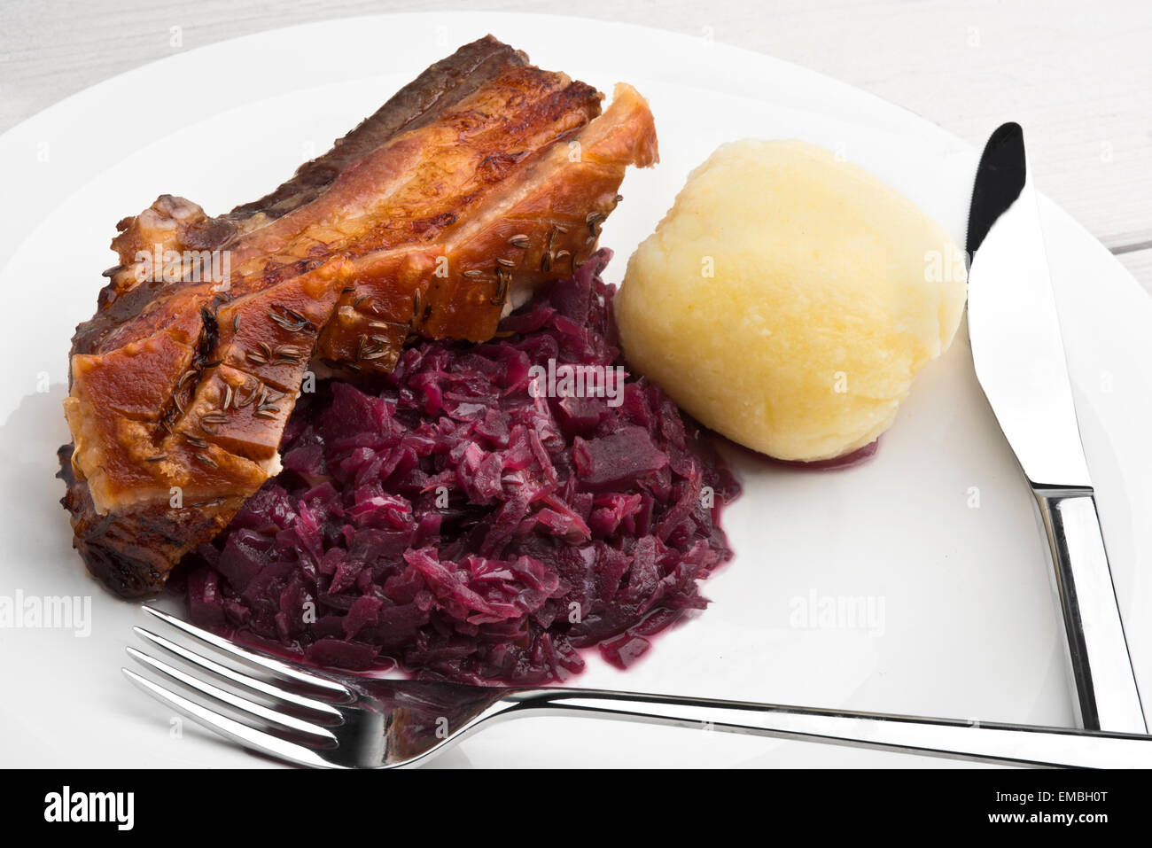 Schweinebauch-Braten mit Kümmel gewürzt Knistern, rotes Sauerkraut und deutschen Stil Kartoffelknödel Stockfoto