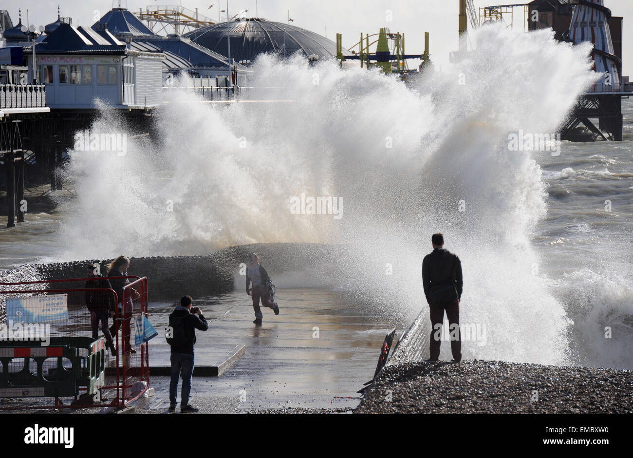 Brighton UK 223. Februar 2015 - eine junge Frau weicht eine riesige Welle, wie es heute über die Buhne neben dem Pier in Brighton Meer stürzt. Menschen versammelten sich am Strand und Meer zu beobachten, dass die Wellen bei Flut als eine weitere Reihe von ungewöhnlichen Super Gezeiten in ganz Großbritannien Foto genommen von Simon Dack fällig waren Stockfoto