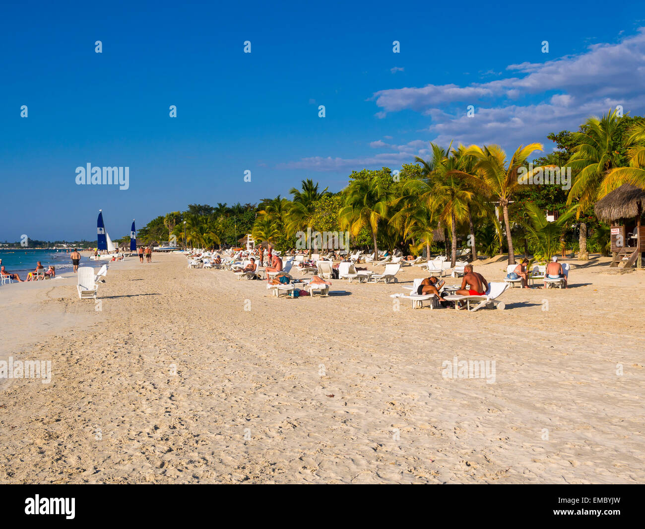 Negril, Jamaika-Blick zum Sandstrand mit Liegewiese Touristen Stockfoto