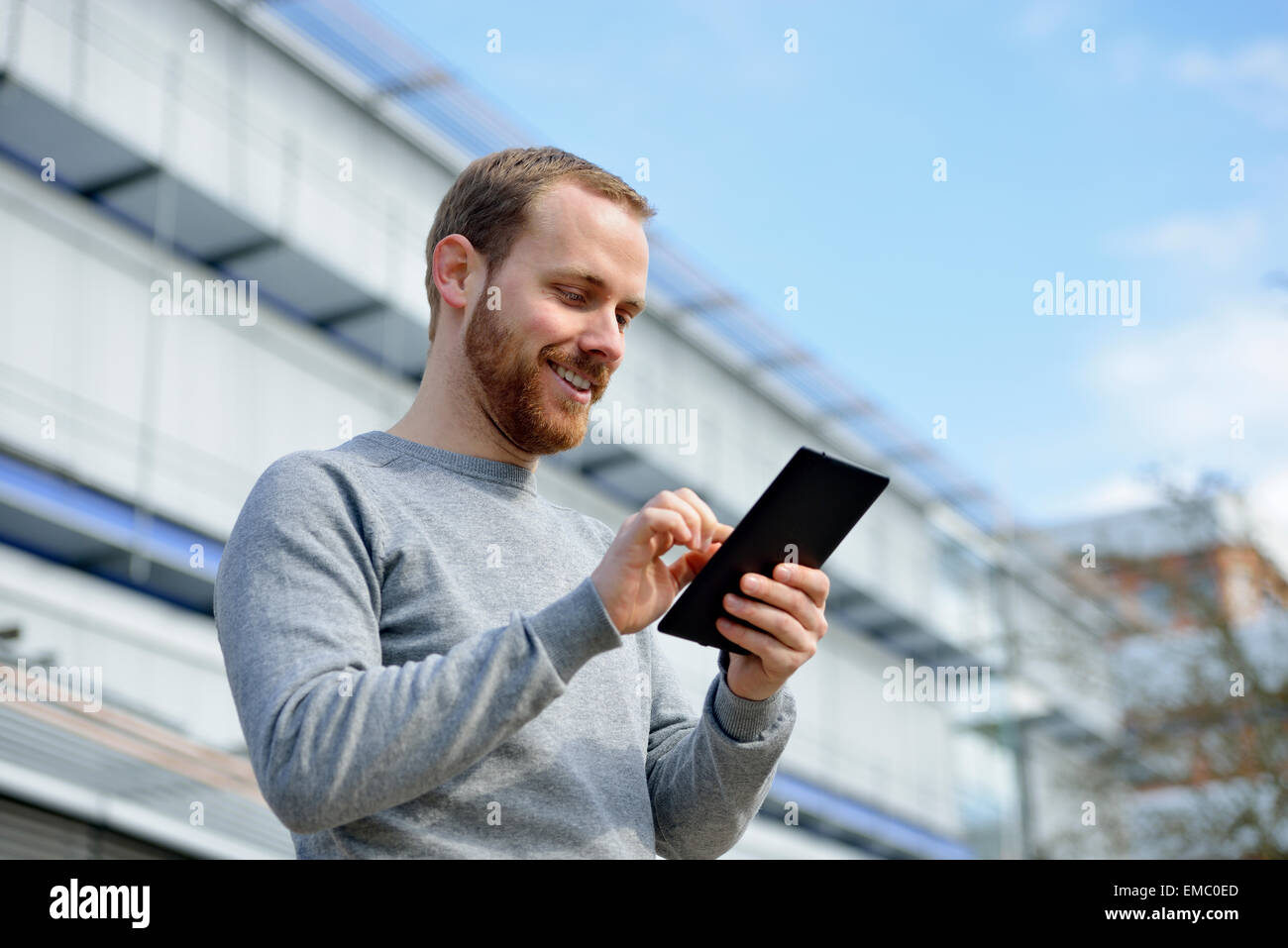 Porträt von lächelnden jungen Mann mit Mini-tablet Stockfoto