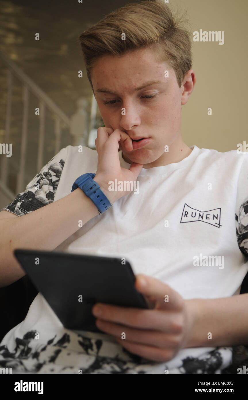 Teenage Boy Verwendung An Apple iPad Tablet Stockfoto