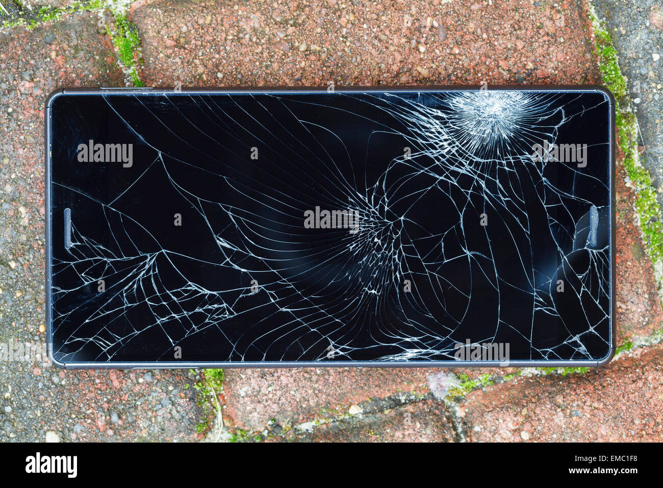 Handy mit einem gebrochenen Bildschirm liegen auf Fahrbahn Stockfoto
