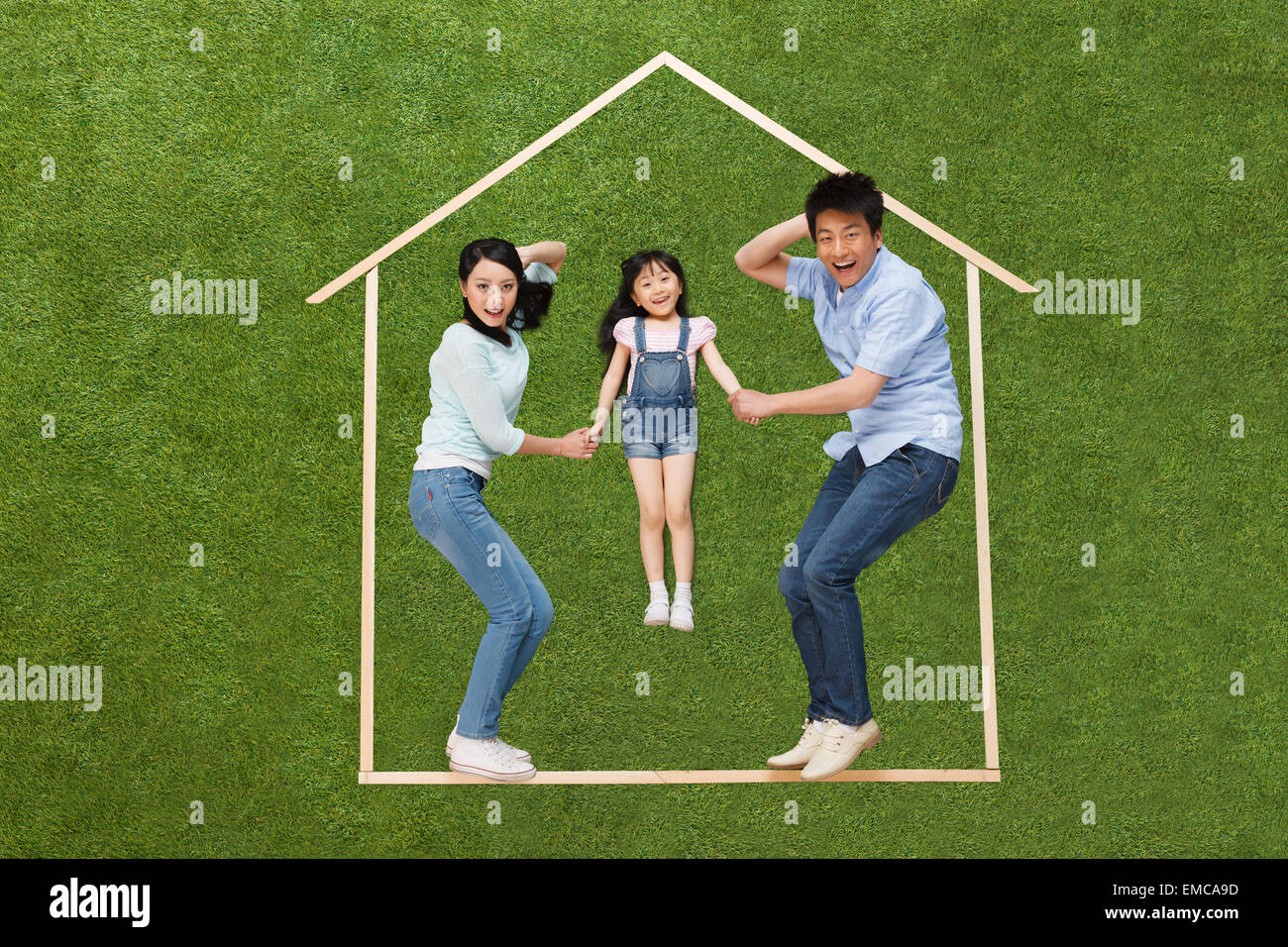 Das Glück, eine Familie mit drei liegen auf dem Rasen in der Musterhaus Stockfoto