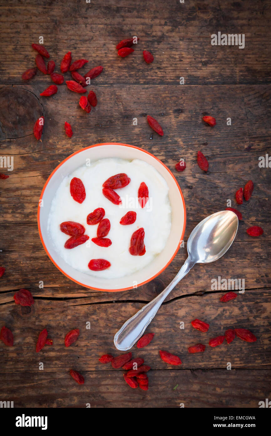 Schüssel mit Naturjoghurt mit Wolfberries und Tee-Löffel Stockfoto