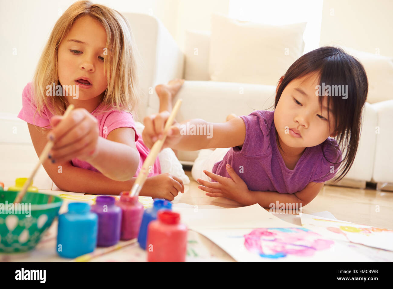 Zwei Mädchen am Boden und Malerei Bild zu Hause liegen Stockfoto
