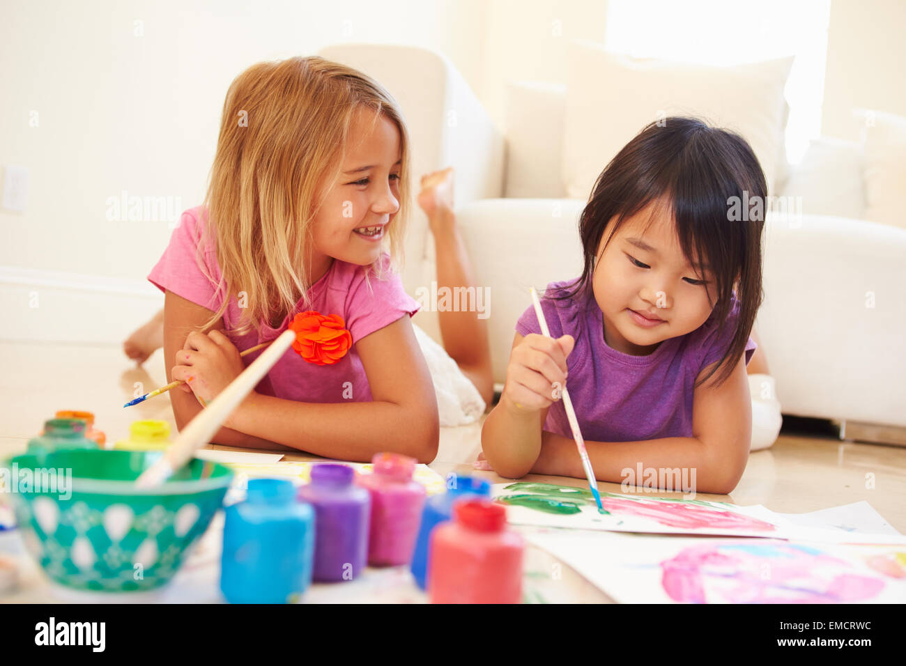Zwei Mädchen am Boden und Malerei Bild zu Hause liegen Stockfoto