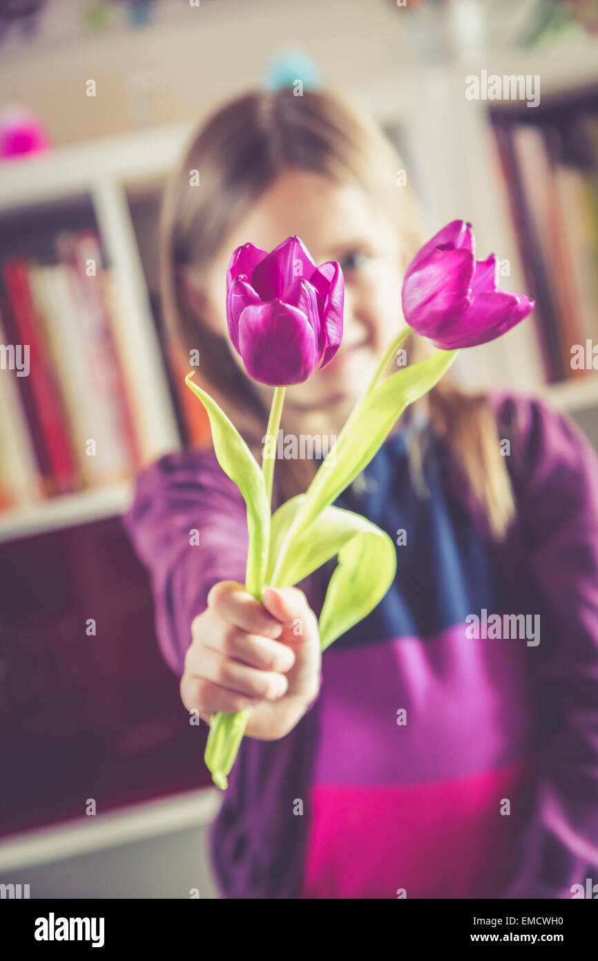 Kleines Mädchen mit zwei violette Tulpen Stockfoto