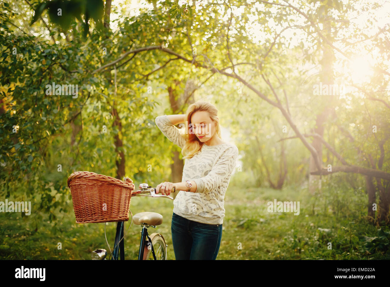 Junge blonde schöne Frau auf einem Vintage Fahrrad im Park. Hipster-Stil. Korn für besten Eindruck hinzugefügt. Stockfoto