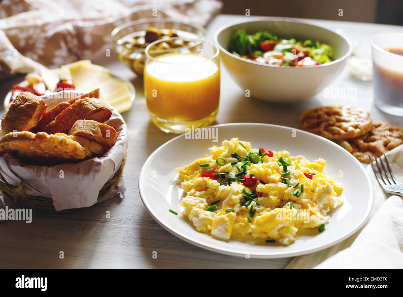 Frühstückstisch mit Rührei, frisches Brot, Orangensaft morgens Sonne zu Hause. Selektiven Fokus. Stockfoto