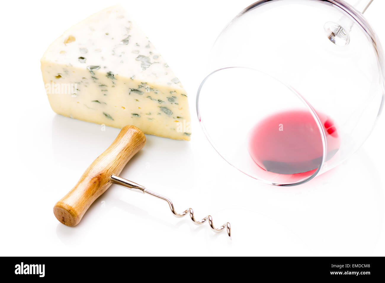 Stück Blauschimmelkäse mit Weinglas und Korkenzieher auf weißem Hintergrund. Stockfoto