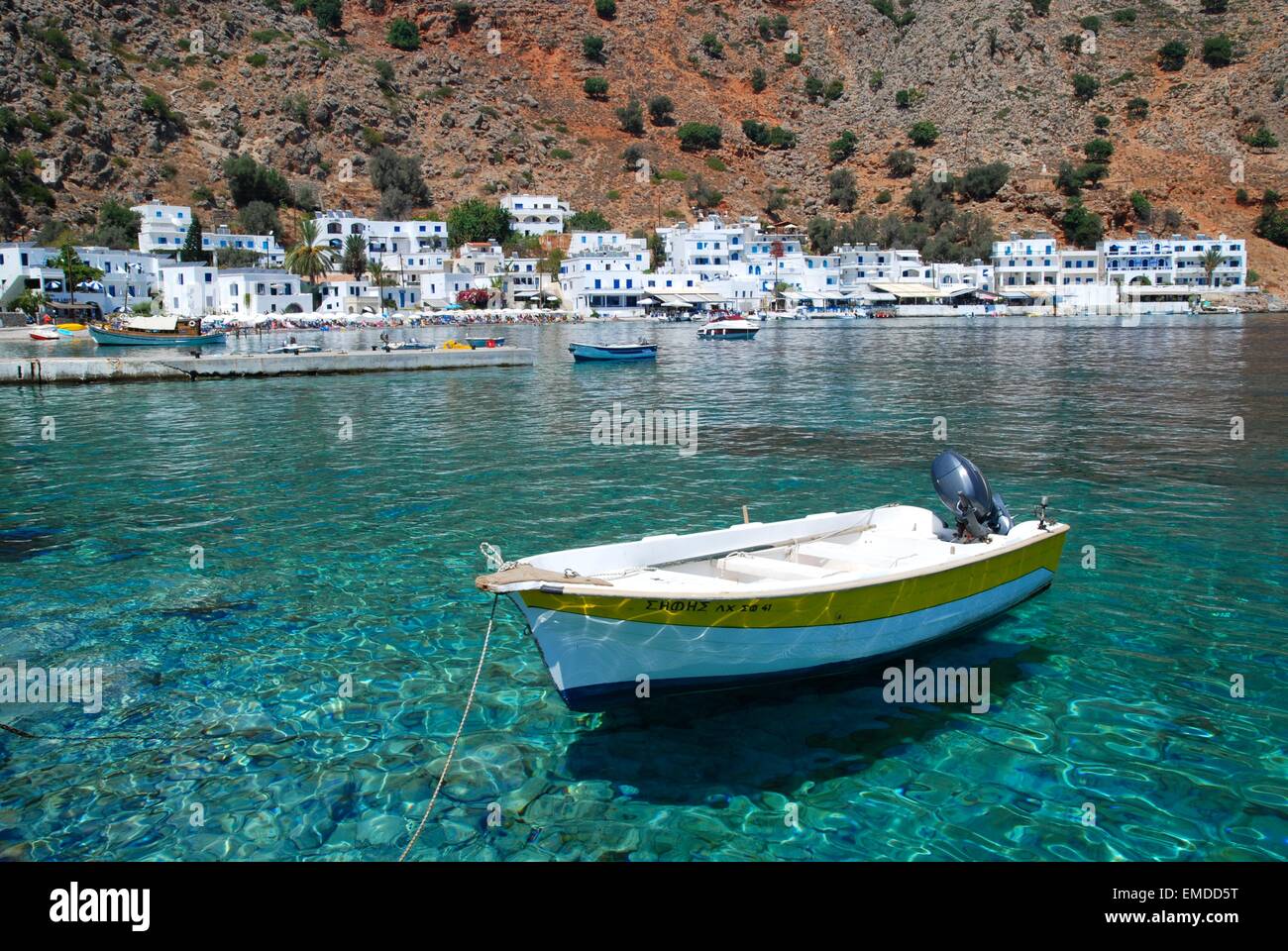 Kleines Boot auf kristallklarem türkisblauem Meerwasser in dem malerischen weiß getünchten Dorf Loutro, Südwestkreta, Griechenland Stockfoto