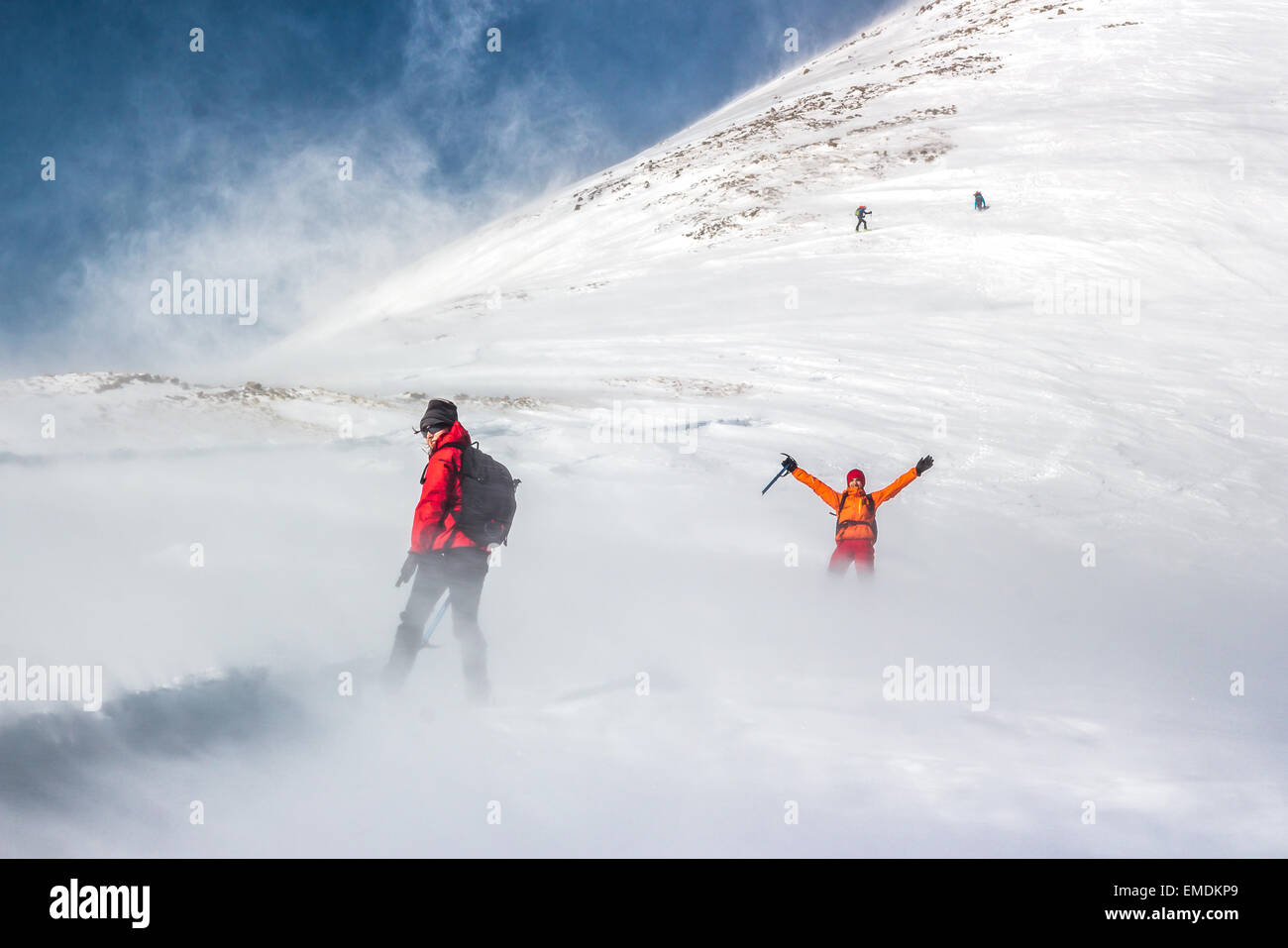 Bergsteiger und Wind weht Schnee. Stockfoto