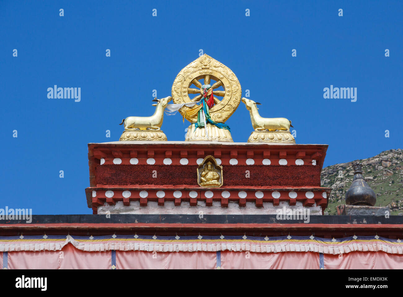 Zwei goldene Hirsch flankieren ein Dharma-Rad an dem Drepung-Kloster in Tibet in der Nähe von Lhasa. Das Hotel liegt auf dem Gambo Utse Berg Drepung Stockfoto