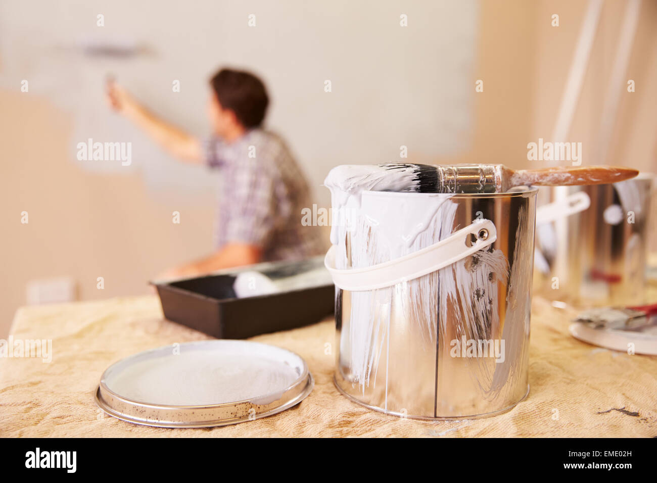 Mann Dekoration Zimmer mit Farbroller auf Wand Stockfoto