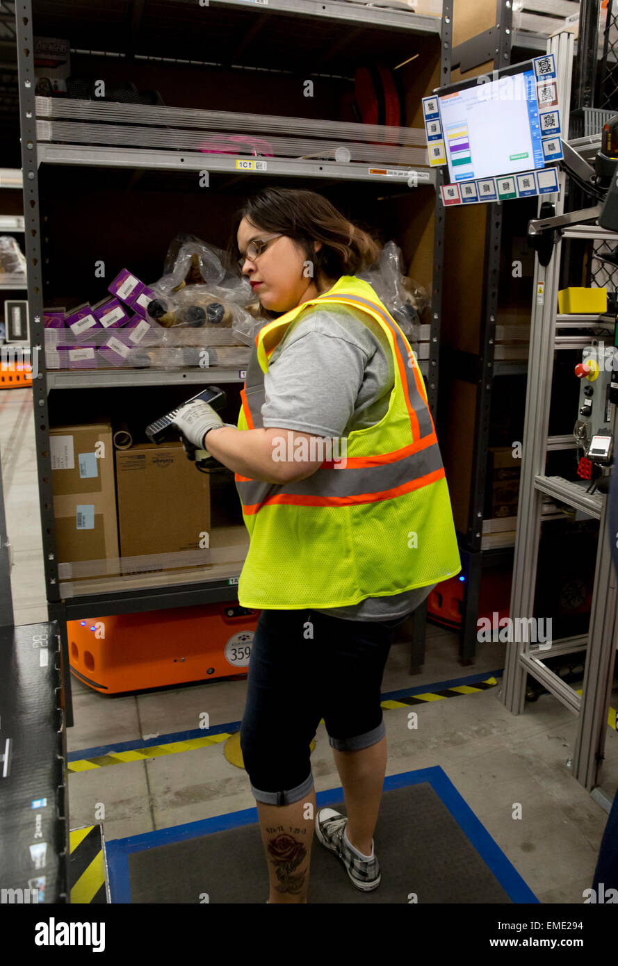 Hispanic Arbeitnehmerin bei Amazon Fulfillment-Center verfolgt Pakete im Lager Stockfoto