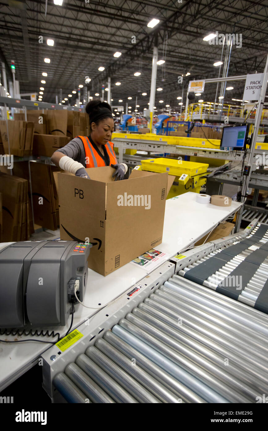African-American Arbeitnehmerin Pakete Elemente in Boxen bei Amazon Fulfillment-Center in Texas Stockfoto