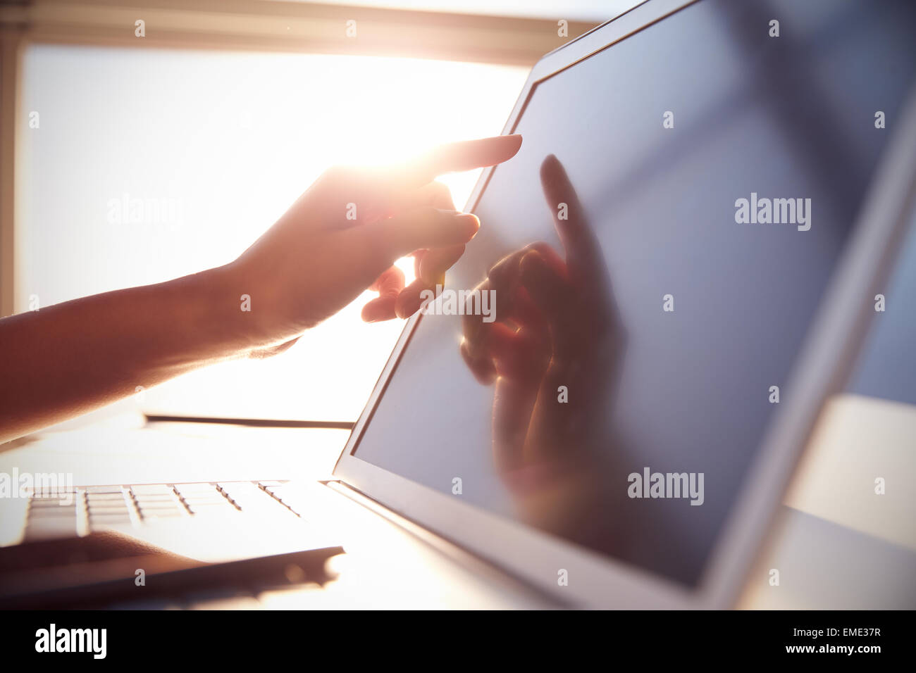 Close Up Hand berühren Laptop-Bildschirm mit Lens Flare Stockfoto