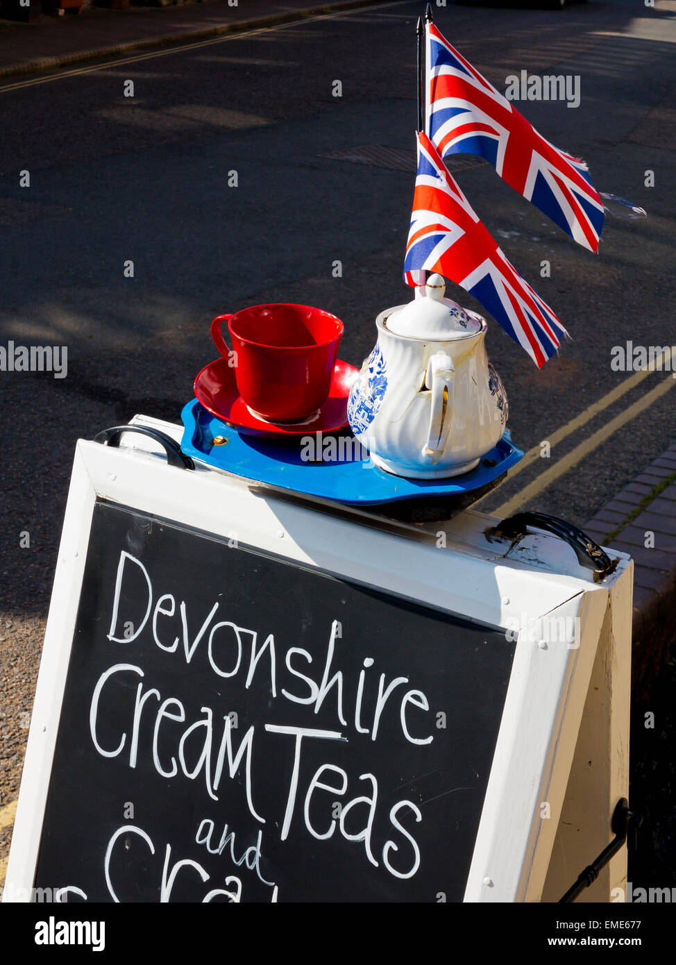 Sandwichbrett Zeichen Werbung Devonshire Cream Teas mit einem Tablett mit einer Tasse, Untertasse, Teekanne und Union Jack-Flaggen an der Spitze Stockfoto