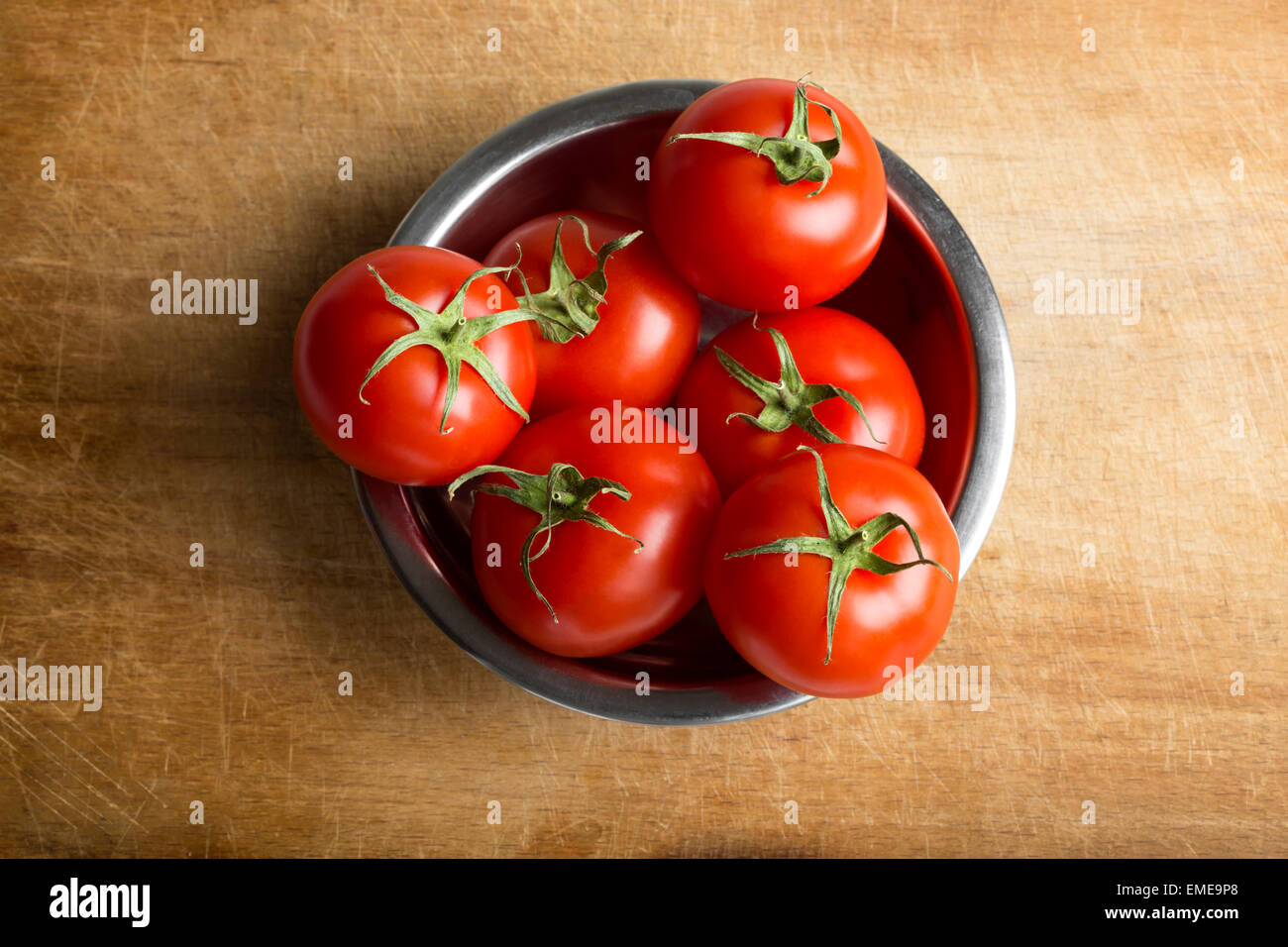 Reife Kirschtomaten in Metallschale auf hölzernen Hintergrund Stockfoto