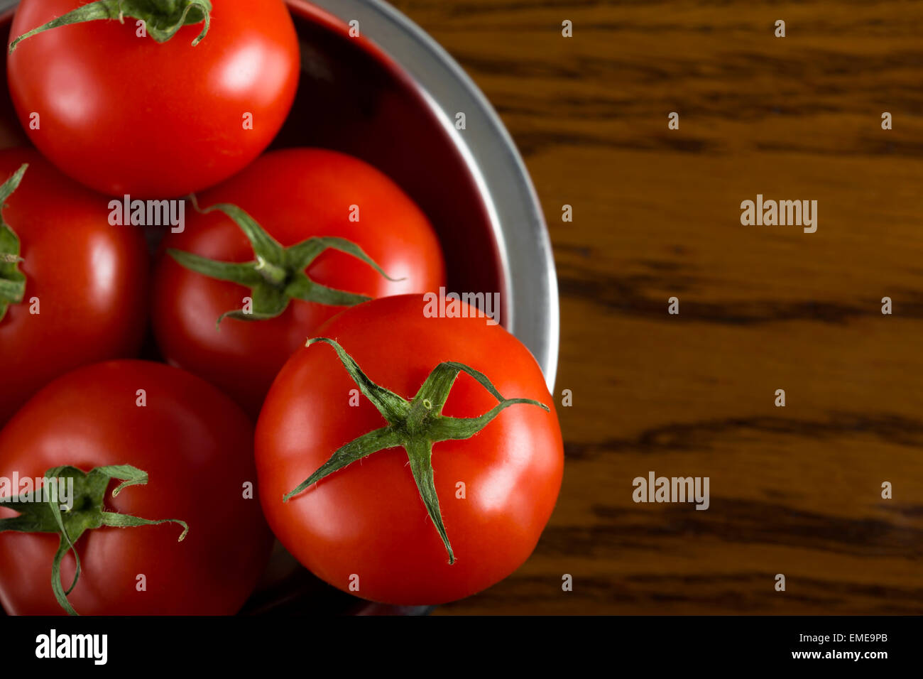 Nahaufnahme von einigen frischen Cherry-Tomaten in Metallschale auf hölzernen Hintergrund Stockfoto