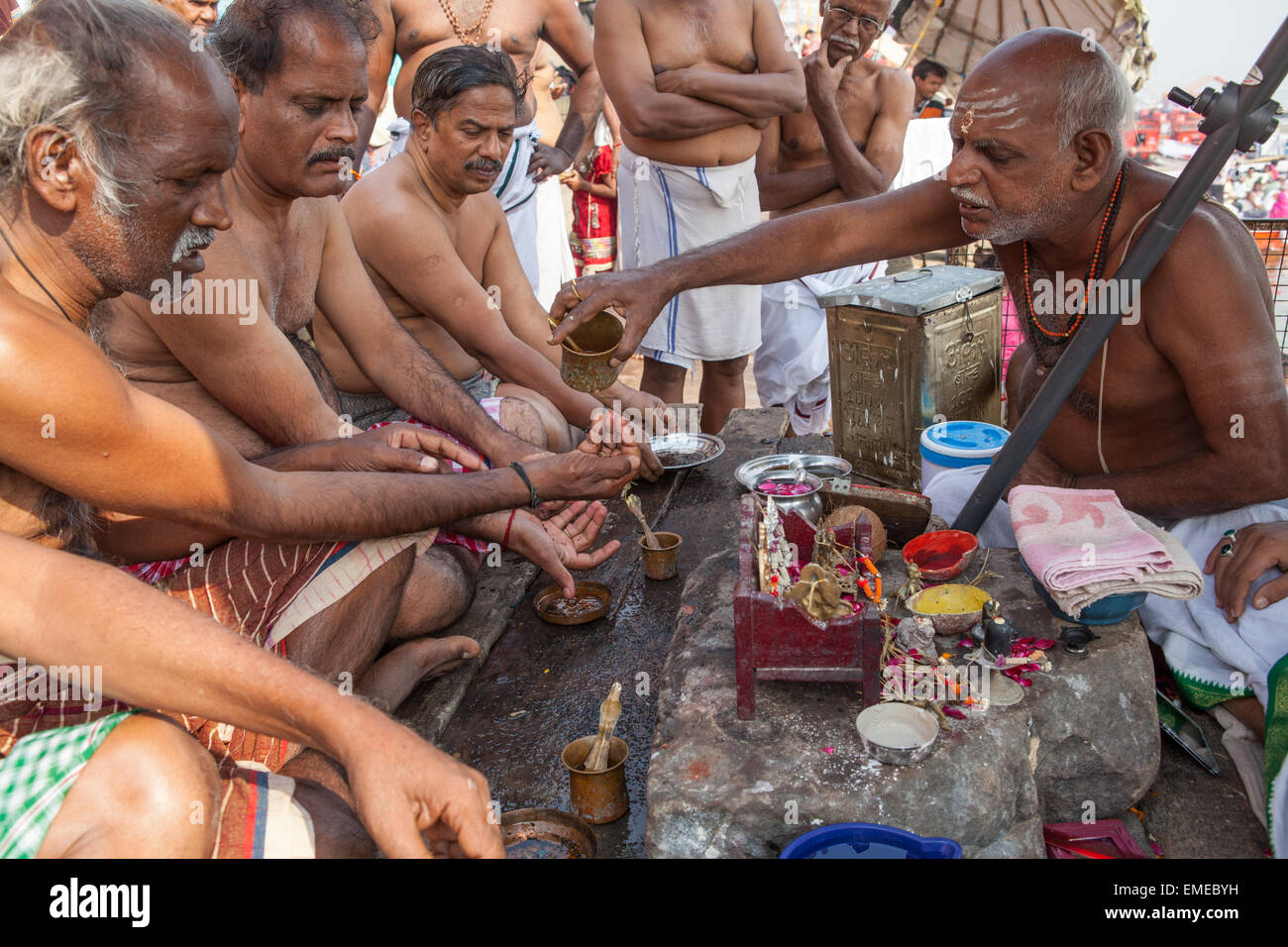 Ein Pandit (heiliger Mann und Priester, die Zeremonien durchführt) führt bei Pilgern und Gläubigen auf den Ghats in Varanas Puja (Gebet) Stockfoto