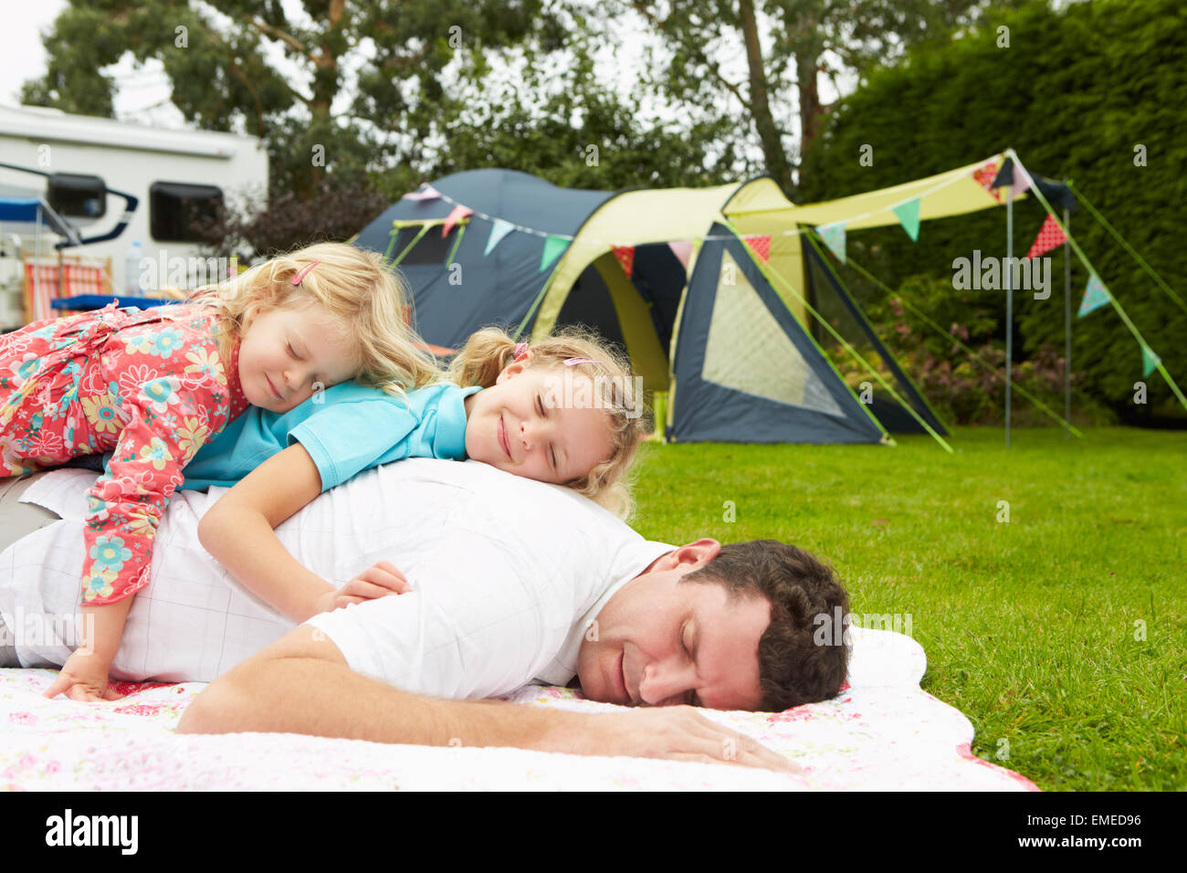 Vater mit Kindern entspannend auf Campingurlaub Stockfoto