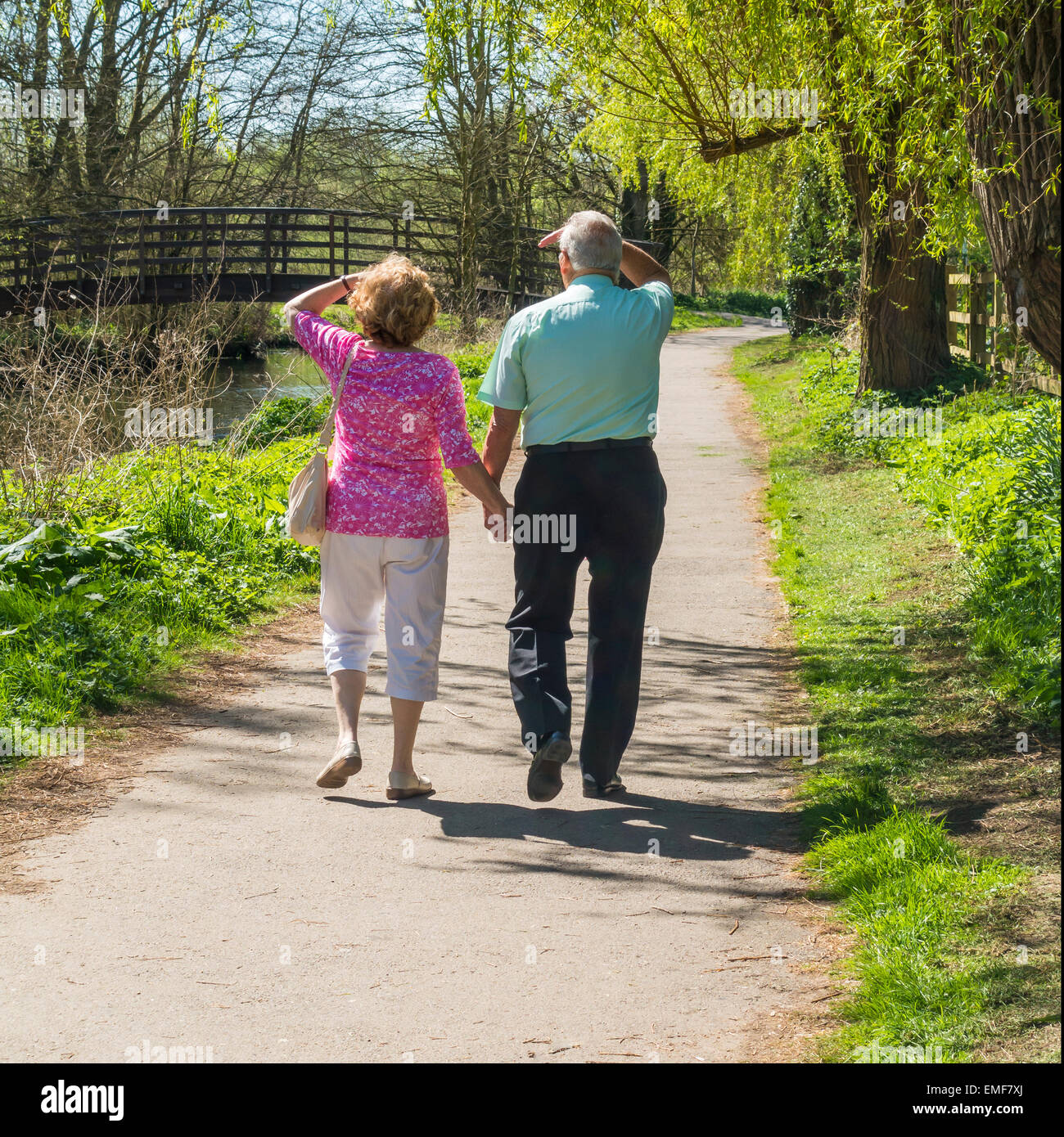 Älteres Ehepaar zu Fuß halten Hände am Flussufer Land gehen Stockfoto