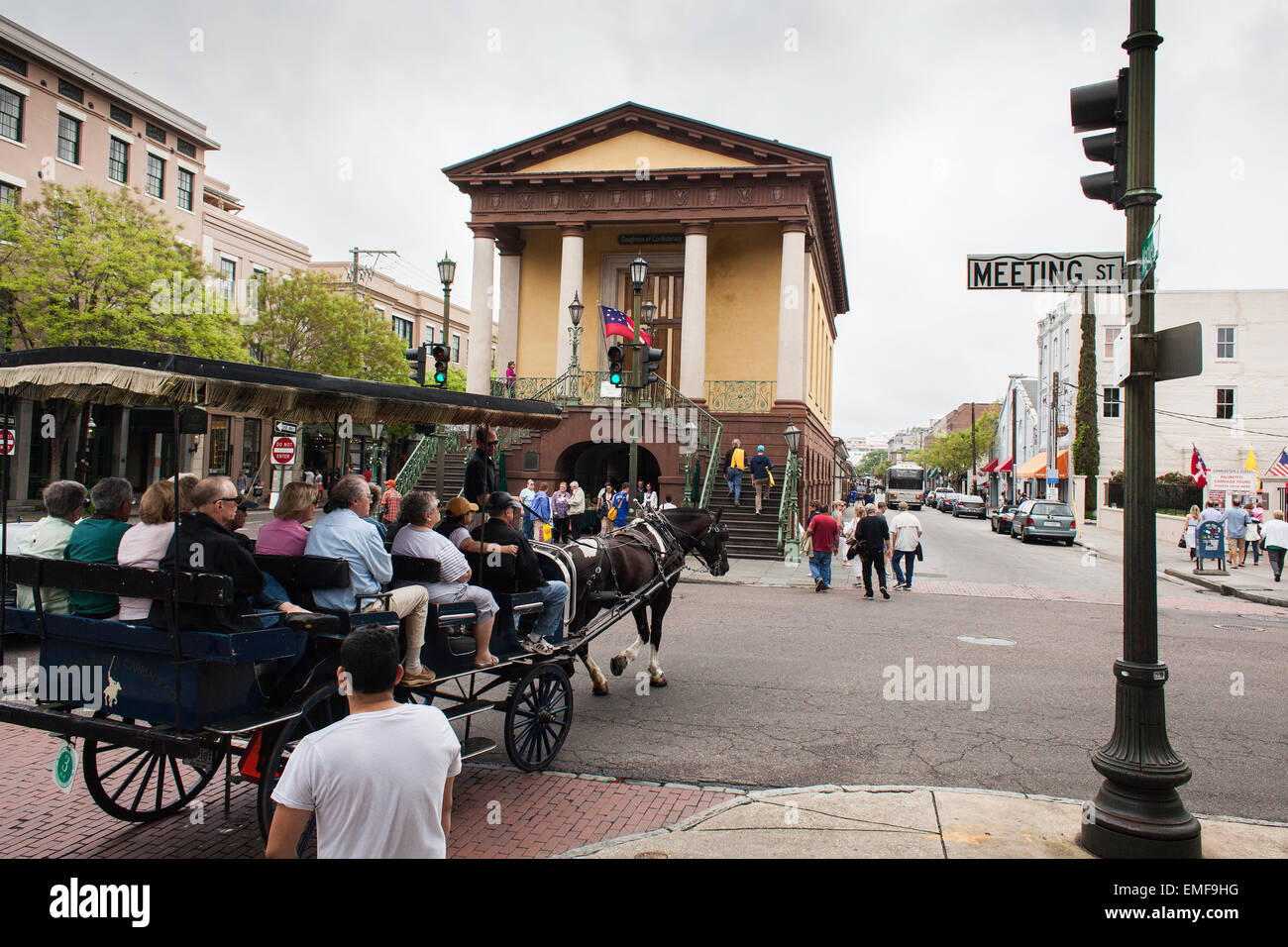 Eine Pferdekutsche mit Touristen überquert die Kreuzung der Meeting Street und Market St. in Charleston, South Carolina Stockfoto
