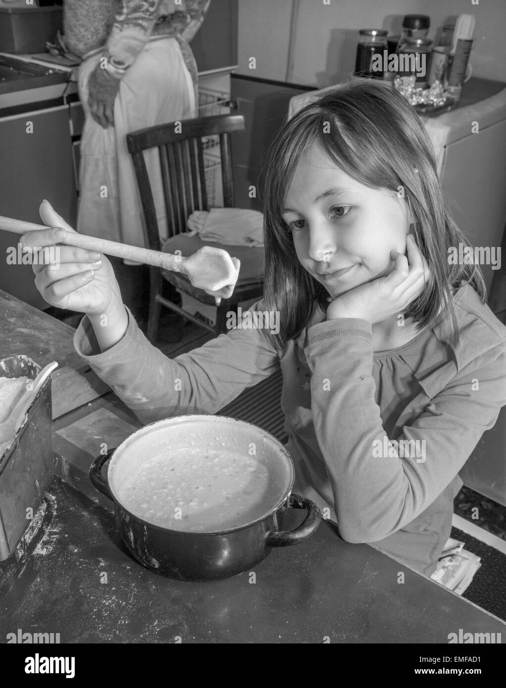 junges Mädchen Wuchsverhalten beim cooking - Gebotes Stockfoto