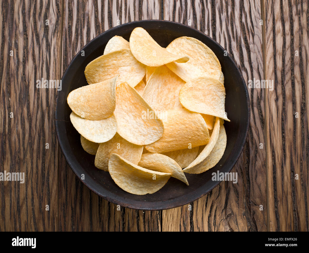 Kartoffel-Chips auf einem hölzernen Hintergrund. Stockfoto